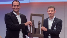 Eike-Niklas Jung and Dr. Michael Steinbeck holding the Prize in their hands. 