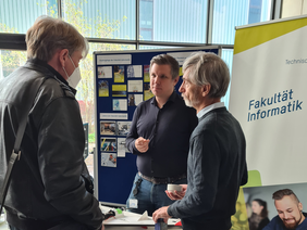 Professoren Jarschel und Gold im Gespräch mit Lehrer am Stand der Fakultät Informatik