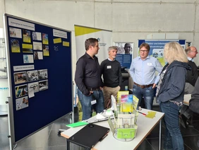 Professors Jarschel, Gold and Frey talking to a teacher at the Faculty of Computer Science´s stand