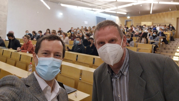 Selfie von Prof. Locher und Prof. Schmidt mit zahlreichen Erstsemestern in einem voll besetzten Hörsaal