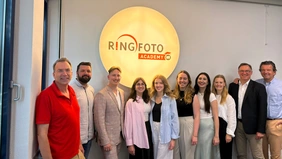 Eine Gruppe Menschen mit dem Logo von Ringfoto Academy im Hintergrund.